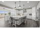 Spacious kitchen featuring white cabinets, a large island with seating, and views from plentiful windows at 9021 Swan River St, Littleton, CO 80125