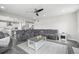Open-concept living area with a cozy sectional and a view of the kitchen and staircase at 9021 Swan River St, Littleton, CO 80125