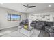 Bright living room with ample natural light, hardwood floors, and a comfortable gray sectional at 9021 Swan River St, Littleton, CO 80125