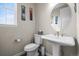 Stylish powder room with modern fixtures, decorative mirror, and custom artwork at 9021 Swan River St, Littleton, CO 80125