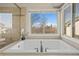 Bright bathroom featuring a soaking tub, and large window with neighborhood views at 853 Huntington Dr, Highlands Ranch, CO 80126