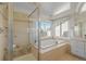 Bright bathroom featuring a glass enclosed shower, soaking tub, and large window at 853 Huntington Dr, Highlands Ranch, CO 80126