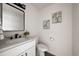 Stylish half bathroom with marble countertop, black hardware, and decorative wall art at 9316 W Utah Ave, Lakewood, CO 80232