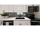 Modern kitchen features white cabinets, quartz countertops, black hardware and stainless steel appliances at 9316 W Utah Ave, Lakewood, CO 80232