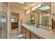 Bathroom showcasing double sinks with a big mirror, sky light, and glass shower at 2686 S Cherokee St, Denver, CO 80223