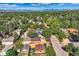 Aerial view of property nestled among trees with mountain views in the background at 2692 N Raleigh St, Denver, CO 80212