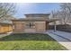 Lovely back exterior highlighting brickwork, covered patio, green lawn and wooden fence, all bathed in sunlight at 2692 N Raleigh St, Denver, CO 80212