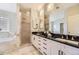 Modern bathroom featuring double sinks, granite counters, ample mirror space and a separate shower and tub at 2692 N Raleigh St, Denver, CO 80212