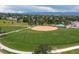 A pristine baseball field surrounded by green grass and trees, ready for exciting games and community events at 9856 Keenan St, Highlands Ranch, CO 80130