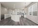 Open-concept kitchen featuring white cabinets, modern appliances, with dark hardwood floors at 9856 Keenan St, Highlands Ranch, CO 80130