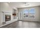 Cozy living room with a fireplace, built-in shelving, and large windows for natural light at 9856 Keenan St, Highlands Ranch, CO 80130