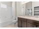 Bright bathroom featuring a double sink vanity with dark cabinets and a shower over the tub at 14301 E Tennessee Ave # 109, Aurora, CO 80012
