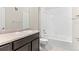 Well-lit bathroom with a shower over the tub and a vanity with dark cabinets at 14301 E Tennessee Ave # 109, Aurora, CO 80012