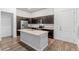 Contemporary kitchen featuring dark cabinetry, an island, and stainless steel appliances at 14301 E Tennessee Ave # 109, Aurora, CO 80012