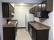Functional kitchen featuring dark cabinets, tan countertops, and standard appliances at 16359 W 10Th Ave # 1, Golden, CO 80401
