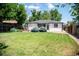 Expansive backyard featuring a lush lawn, mature trees, and a patio perfect for outdoor entertaining at 2294 W Parkhill Ave, Littleton, CO 80120