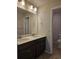 Bathroom featuring double sinks, neutral countertops and dark wood cabinets at 6046 Keyser Pl, Brighton, CO 80601