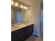 Bathroom with double sink vanity, well-lit mirror and ceramic tile flooring at 6046 Keyser Pl, Brighton, CO 80601