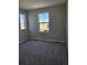 Bedroom with carpet and views from the two large windows at 6046 Keyser Pl, Brighton, CO 80601