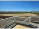 Back deck overlooking a green field and farm in the distance at 6046 Keyser Pl, Brighton, CO 80601