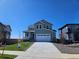 Charming two-story home with a wide driveway, manicured lawn, and a welcoming front porch at 6046 Keyser Pl, Brighton, CO 80601