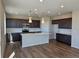 Open kitchen features a center island with a sink, modern cabinets, and pendant lighting at 6046 Keyser Pl, Brighton, CO 80601
