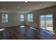 Bright living room with hardwood floors, large windows, and access to outdoor deck at 6046 Keyser Pl, Brighton, CO 80601