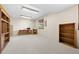 Large unfinished basement space features carpeted floors, wooden shelves, and an exterior view from the window at 25019 N Mountain Park Dr, Evergreen, CO 80439