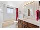 Bright bathroom with a shower-tub combo, single sink vanity, and elegant fixtures and decor at 25019 N Mountain Park Dr, Evergreen, CO 80439