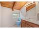 Simple bathroom with a blue toilet, single sink, a wooden vanity, and white patterned walls and floors at 25019 N Mountain Park Dr, Evergreen, CO 80439