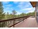 A wrap-around wooden deck provides ample space to enjoy views of the surrounding trees and partial mountain range at 25019 N Mountain Park Dr, Evergreen, CO 80439
