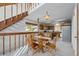 Cozy dining area features a wooden table and chairs set near the kitchen and a staircase with wooden railings at 25019 N Mountain Park Dr, Evergreen, CO 80439