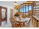 Charming dining room featuring a wooden table, large windows, and wood-paneled walls at 25019 N Mountain Park Dr, Evergreen, CO 80439