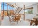 Bright dining area with a wooden table, staircase, and large windows with a view at 25019 N Mountain Park Dr, Evergreen, CO 80439