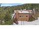 Two-story home with a walk out basement, a two car garage and snowy landscape at 25019 N Mountain Park Dr, Evergreen, CO 80439