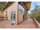 Exterior view of the home features the deck, large windows, and surrounding treeline at 25019 N Mountain Park Dr, Evergreen, CO 80439