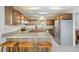 Spacious kitchen featuring wooden cabinets, stone countertops, and stainless steel refrigerator at 25019 N Mountain Park Dr, Evergreen, CO 80439