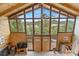 Bright living room featuring wood-paneled walls, vaulted ceilings, a fireplace, and expansive windows with mountain views at 25019 N Mountain Park Dr, Evergreen, CO 80439