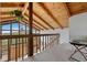Open loft area features a rustic wood railing, vaulted ceilings, and views to the living room below at 25019 N Mountain Park Dr, Evergreen, CO 80439