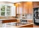 Bright kitchen featuring wood cabinets, stone countertops, stainless steel oven, and a window bringing in natural light at 17705 W 63Rd Dr, Golden, CO 80403