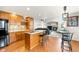 Open concept kitchen and living room, featuring wood floors, stainless steel appliances, kitchen island, and fireplace at 17705 W 63Rd Dr, Golden, CO 80403