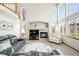 Bright living room featuring high ceilings, fireplace, large windows with window shutters, and comfortable seating at 17705 W 63Rd Dr, Golden, CO 80403