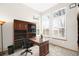 Well-lit home office with custom shelving, a large desk, and plenty of natural light at 17705 W 63Rd Dr, Golden, CO 80403