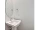 Modern powder room features a pedestal sink, chrome fixtures, and oval mirror at 710 Belay St, Erie, CO 80516