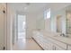 Bright bathroom featuring double sinks, a large mirror, plenty of storage, and a glass-enclosed shower at 710 Belay St, Erie, CO 80516