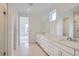 Stylish bathroom with dual sinks, white cabinets, marble countertops, and glass shower door at 710 Belay St, Erie, CO 80516