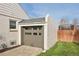 Detached garage with a gray door, brick exterior, and well-maintained landscaping adding convenience and curb appeal at 2830 Forest St, Denver, CO 80207