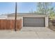 A detached one-car garage with a gray door and tan siding is a nice addition to this property at 2830 Forest St, Denver, CO 80207