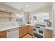 Bright kitchen with wood cabinetry, open shelves, white backsplash, and a view into another room at 2830 Forest St, Denver, CO 80207
