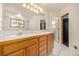 Primary bathroom with double sinks, oak cabinets, large mirror and tiled floor with stained glass window at 2072 Skylark Ct, Longmont, CO 80503